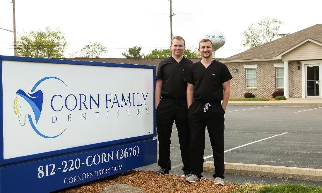 Dr. Nathan Corn and Dr. Derek Corn beside the Corn Family Dentistry sign at our Edinburgh office