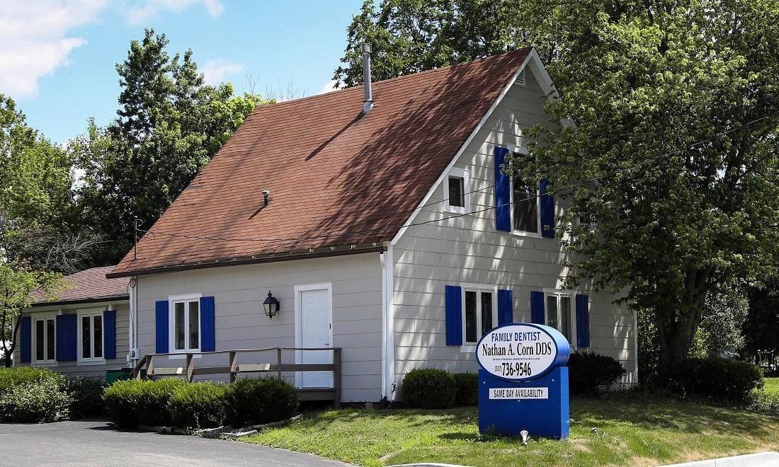 Our Franklin office: a white cottage with blue shutters and the oval sign out front